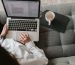 crop woman using laptop on sofa at home